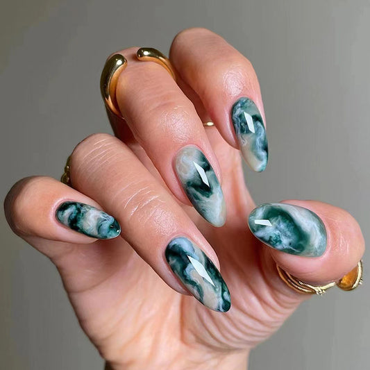 Aqua marble nails showcasing a blend of aqua and soft white swirls, creating a fluid marble effect for a fresh and trendy appearance.