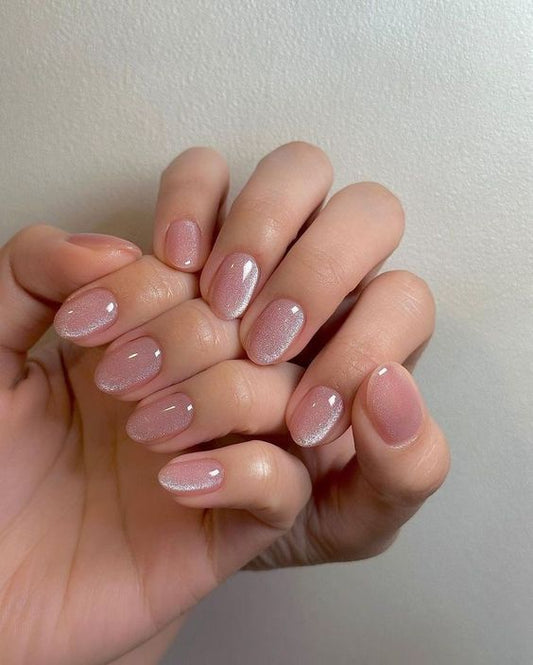 Charming baby pink cat eye nails featuring a smooth pink surface and a mesmerizing cat eye effect, perfect for a stylish and playful manicure.
