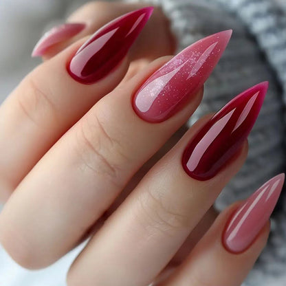 Almond-shaped press-on nails featuring a vibrant mix of bold pink and red colors, creating a striking and eye-catching design.