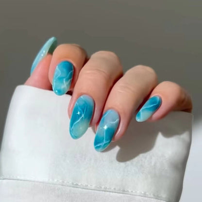 "Elegant marble blue press-on nails with a glossy finish."