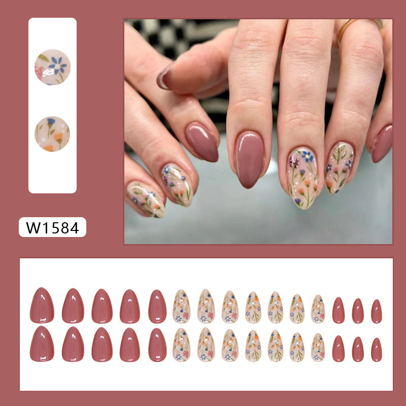 Chic press-on nails in a nude shade with intricate floral patterns, perfect for adding a touch of natural beauty to any style.