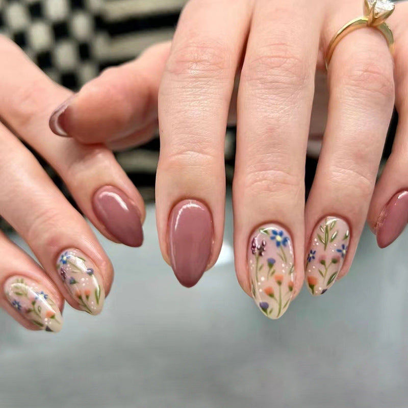 Nude floral press-on nails featuring a soft nude base adorned with delicate floral designs, creating an elegant and feminine look.