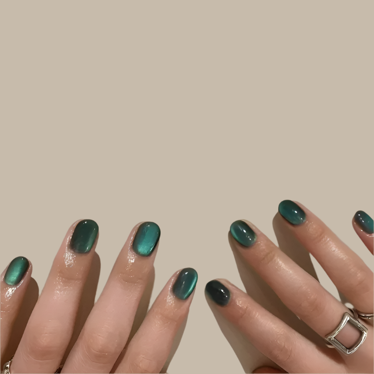 "Teal green cat eye press-on nails with a glossy finish."