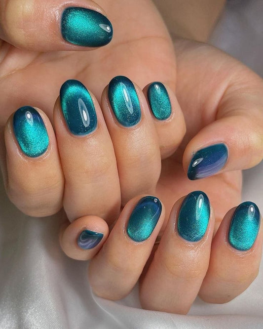 "Shimmering teal green cat eye nails, perfect for any occasion."