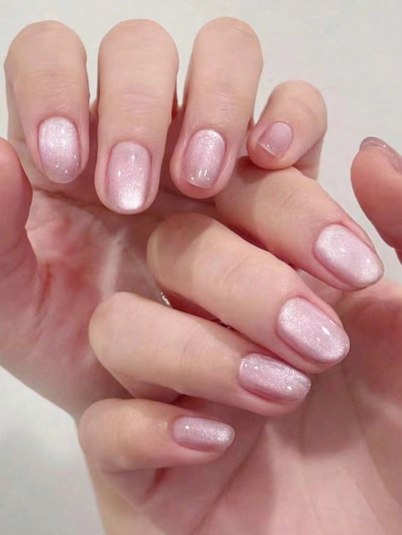 Delicate baby pink cat eye nails showcasing a beautiful blend of light pink tones with a striking cat eye design that catches the light.